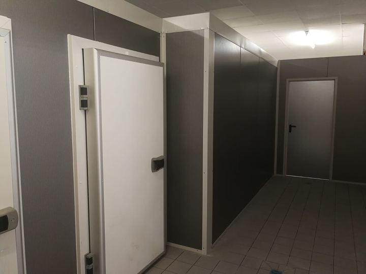 Von Frigano realisierte Kühlzelle: Flur mit anthrazitfarbenen Kühlraumpaneelen und weißer Kühlzellentür